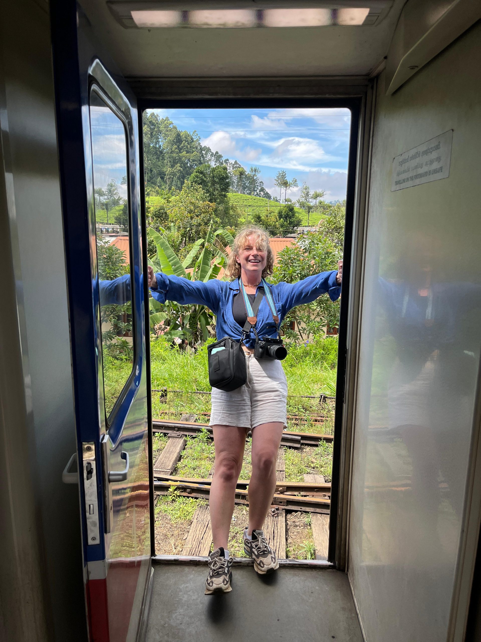 Videographer Marika Hoogenboom smiling with her camera strapped to her in Sri Lanka